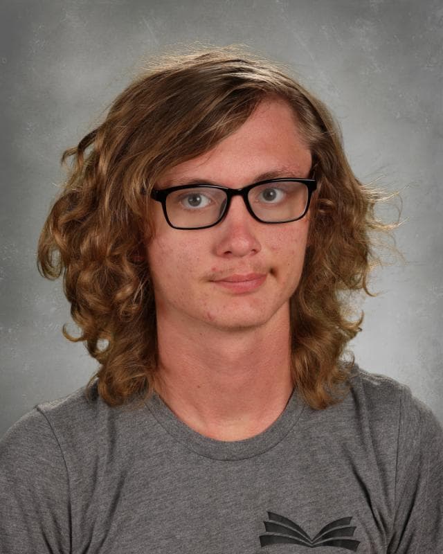 Portrait of Eli Zsiga smiling while holding a camera
